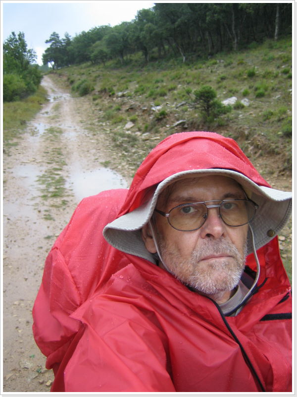 Ulrich im roten Regenponcho auf nassem Weg